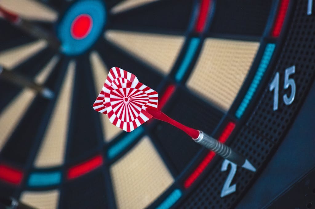 A dart striking the bullseye on a dartboard, showcasing precision and accuracy.