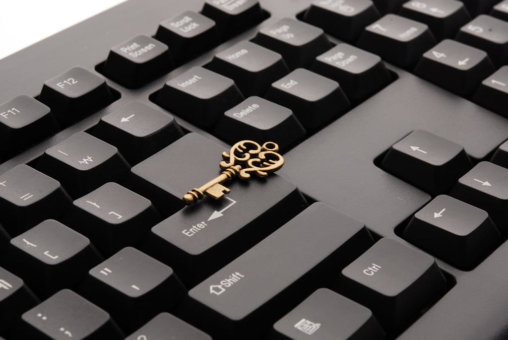 Close-up of an ornate vintage key placed on a modern computer keyboard.