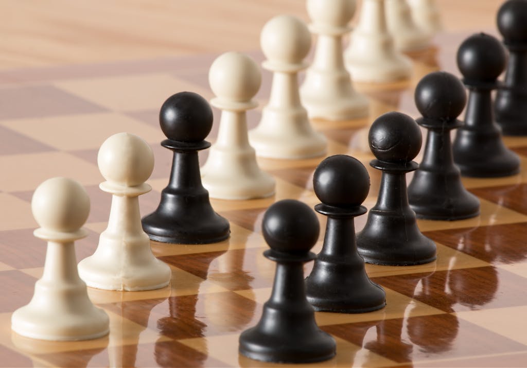 Close-up of chess pawns on a wooden board, symbolizing strategy and intelligence.