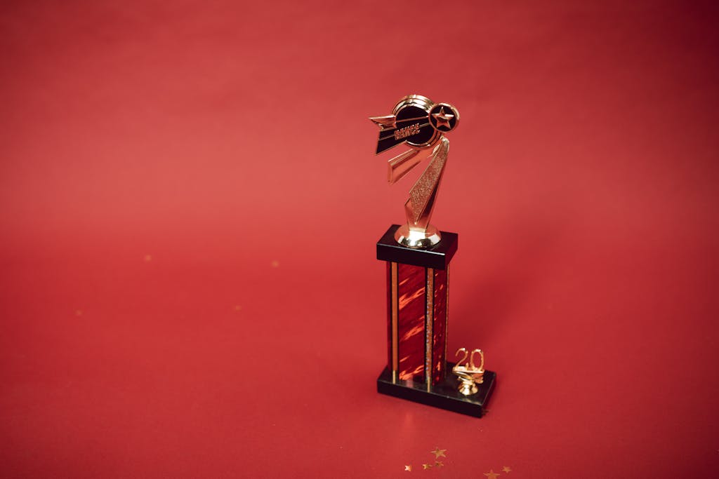 Golden trophy standing on a vibrant red background, symbolizing success and achievement.